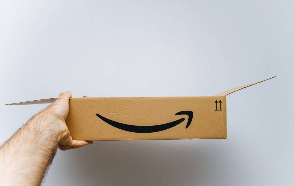 Pessoa segurança uma caixa com o símbolo gráfico do logotipo da Amazon